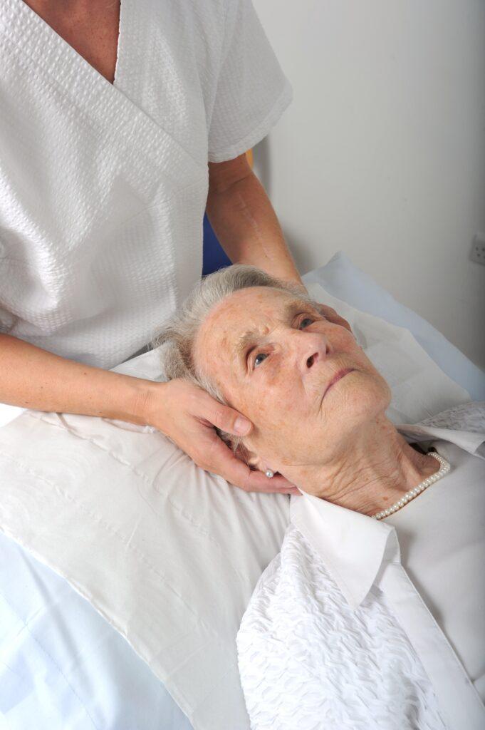 An older lady receiving cranial osteopathy / craniosacral therapy treatment