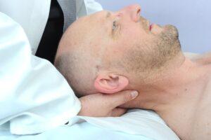 man getting osteopathy treatment for neck pain and headache