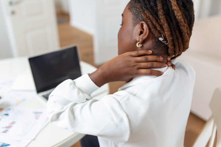 can osteopathy help with neck pain lady sitting at desk with bad neck